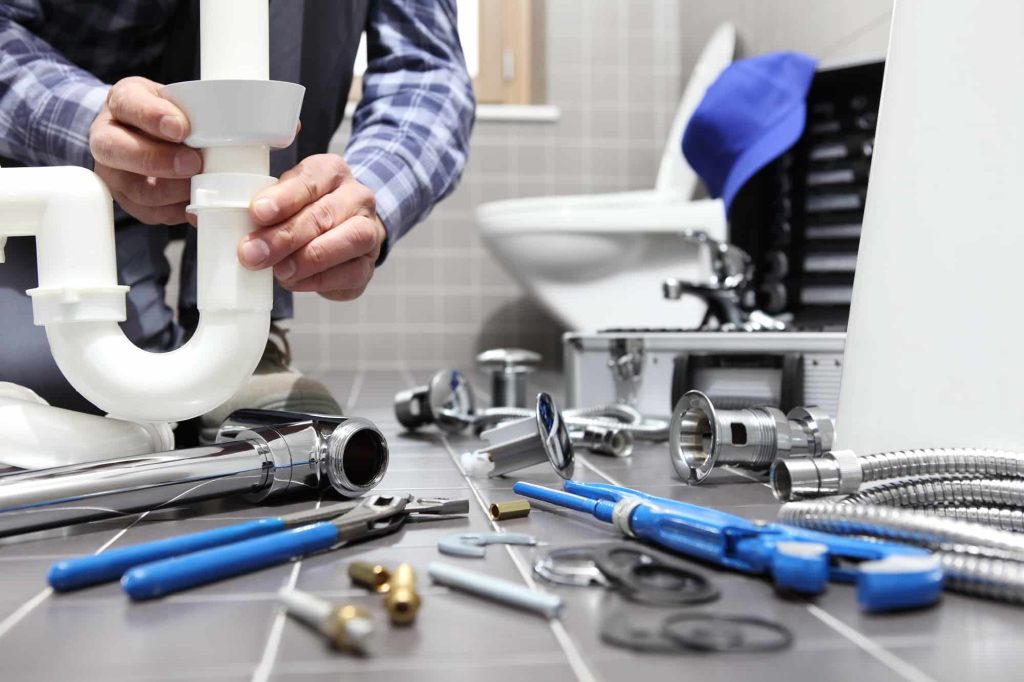 Plumber at work in a bathroom, plumbing repair service, assemble and install concept